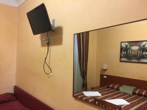 einen Spiegel in einem Zimmer mit einem Bett und einem TV in der Unterkunft Toffa Place In Rome in Rom