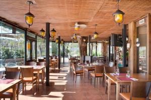 a restaurant with wooden ceilings and tables and chairs at Hotel Las Truchas in Nuévalos