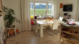 ein Wohnzimmer mit einem weißen Tisch und Stühlen in der Unterkunft Ferienwohnung im Idyll 1 in Hengersberg