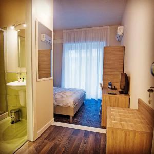 een slaapkamer met een bed en een badkamer met een wastafel bij Emme B&B in Messina