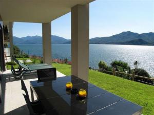 a patio with a table and a view of the water at Appartamento Cicci Bello in Ghiffa