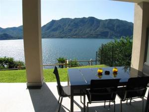 a dining table with chairs and a view of a lake at Appartamento Cicci Bello in Ghiffa