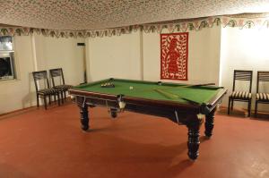 a pool table in a room with chairs at Lohana Village Resort in Pushkar