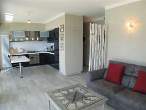 ein Wohnzimmer mit einem Sofa und einem Tisch sowie eine Küche in der Unterkunft Appartamento Cicci Bello in Ghiffa
