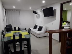 a living room with a table and a white couch at Apartamento con vista al laguito y al mar in Cartagena de Indias