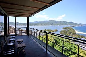 宫津市玄妙庵日式旅馆的带椅子的阳台，可欣赏海景