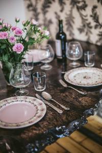 a table with plates and glasses and a bottle of wine at Central High class 3 Bedroom Apartment in Sofia