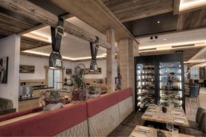 a restaurant with a red counter and wooden ceilings at Hotel Eldorado in Ischgl