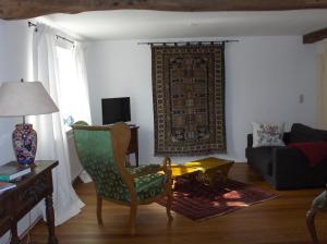 ein Wohnzimmer mit einem Sofa und einem Stuhl in der Unterkunft CARLS KATE in Grömitz an der Ostsee in Grömitz