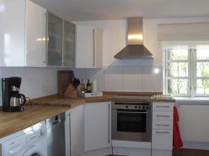 a kitchen with white cabinets and a stove top oven at CARLS KATE in Grömitz an der Ostsee in Grömitz