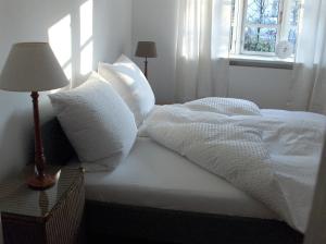 グレーミッツにあるCARLS KATE in Grömitz an der Ostseeの白い枕と窓が備わる白いベッド
