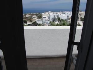 - une vue depuis la porte d'un balcon avec des bâtiments blancs dans l'établissement Villa Garden, à Fira