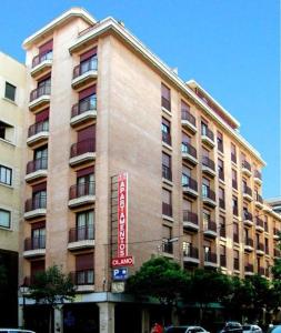 un grand bâtiment avec un panneau sur son côté dans l'établissement Apartamentos Olano C.B., à Madrid