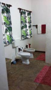 Villa Fortuna Malindi في ماليندي: حمام مع مرحاض ومرآة ونوافذين