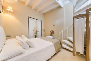 イビサ・タウンにあるDalt vila houseのベッドルーム1室(白いベッド1台、階段付)