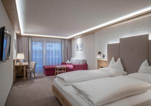 奧伯古格爾的住宿－阿爾盆蘭德酒店，大型酒店客房设有两张床和一张书桌