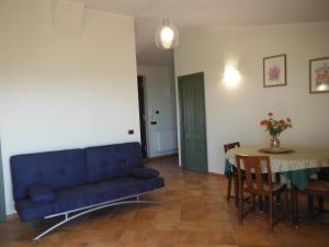 a living room with a blue couch and a table at Alloggio Turistico Ciliegi in Fiore in Monte Libretti