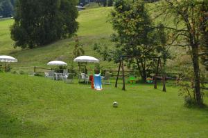 un gruppo di tavoli e sedie con ombrelloni in un campo di Albergo Cioccarelli ad Aprica