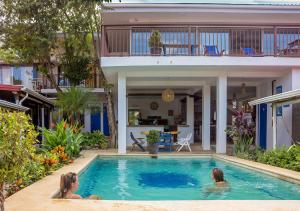 a swimming pool with a dog in it at Hostel La Botella de Leche - Tamarindo in Tamarindo