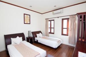 Postel nebo postele na pokoji v ubytování Luang Prabang Legend Hotel