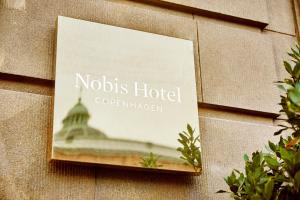 una señal para un hotel al lado de un edificio en Nobis Hotel Copenhagen, a Member of Design Hotels™, en Copenhague