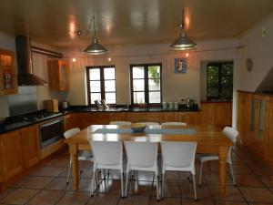 a kitchen with a wooden table and white chairs at Sunset at Diluta in Cape Town
