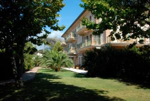 ein großes Apartmenthaus mit Bäumen davor in der Unterkunft Park Hotel Villa Ariston in Lido di Camaiore