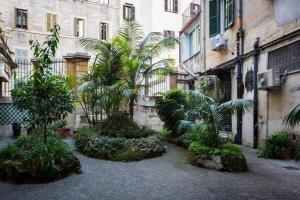 a courtyard with trees and plants in front of a building at The Royal Story in Rome