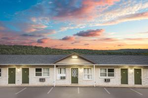 a building with a sunset in the background at Knights Inn Pine Grove in Pine Grove