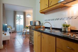 een keuken met een wastafel en een woonkamer bij Quinta do Bom Sucesso in Funchal
