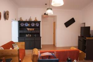 a living room with a couch and a shelf with dishes at Avis Guesthouse in Évora