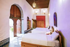 1 dormitorio con 2 camas y puerta abovedada en Dar Drissi, en Fez