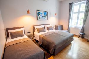 sypialnia z 2 łóżkami i oknem w obiekcie Zagreb City Vibe Apartments & Rooms w Zagrzebiu