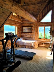 a bedroom in a log cabin with a bed and a treadmill at McDonald's Ranch Lodge in Gardiner