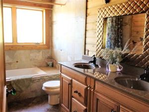 a bathroom with a sink and a toilet and a tub at McDonald's Ranch Lodge in Gardiner +43 photos