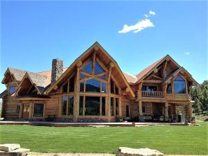 a large wooden house with a green lawn at McDonald's Ranch Lodge in Gardiner