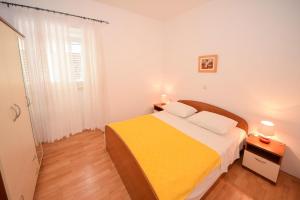 Un dormitorio con una cama amarilla y una ventana en Apartments Bradičić en Orebić