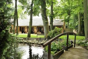 ein Haus mit einer Brücke über einen Teich im Hof in der Unterkunft Logis Le Quai Fleuri in Voves