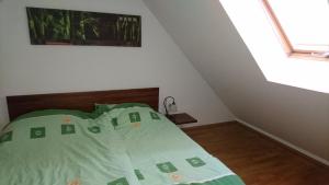 a bedroom with a bed with a green comforter at Apartma GEOTEH Terme Čatež 6032 in Krško