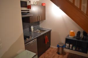 a small kitchen with a sink and a staircase at Duplex à 1 kilomètre de Disneyland Paris in Montévrain