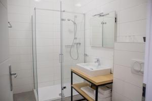 een witte badkamer met een wastafel en een douche bij Zagreb City Vibe Apartments & Rooms in Zagreb