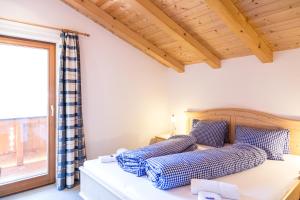 ein Schlafzimmer mit einem Bett mit blauen Kissen und einem Fenster in der Unterkunft Ferienhaus Panorama in Biberwier