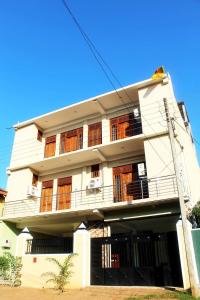 a white building with wooden windows on the side of it at The City Tourist Hotel in Anuradhapura