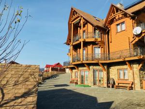 a wooden house with a balcony on the side of it at М House in Vorokhta