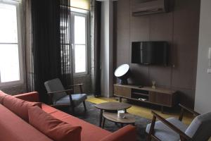 a living room with a red couch and a tv at Bracara Home in Braga