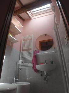 W łazience znajduje się umywalka, toaleta i lustro. w obiekcie The Four Angels w mieście Massa