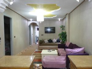uma sala de estar com um sofá e um lustre em appartement Annakhil em Marrakech