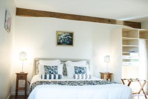 a bedroom with a large white bed with blue pillows at B&B Le Clos du Phare - En campagne in Saint-Samson-de-la-Roque +54 photos