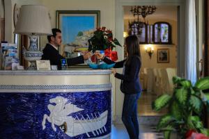 a man and a woman standing at a counter with drinks at Hotel Santa Lucia in Minori