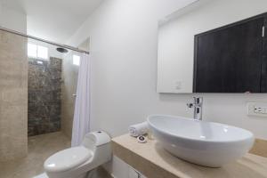 a white bathroom with a sink and a shower at Hotel G Cartagena in Cartagena de Indias